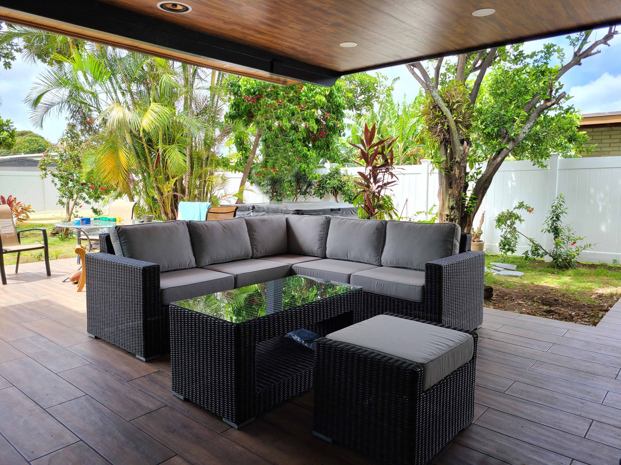 The Sectional 6 Piece with 1 footrest with brown rattan and gray cushions.